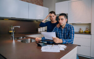 Unemployed young couple with debts reviewing their bank accounts